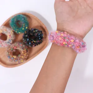 Detalle de coleteros de punto suave en varios colores en la muñeca y bandeja
