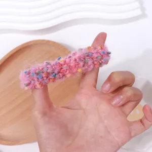 Primer plano de un coletero rosa de punto con textura de lana moteada multicolor