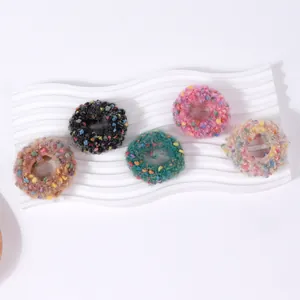 Pack de cinco coleteros de punto con motas de colores en varios tonos suaves
