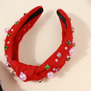 Close-up of red knotted headband with pink faux pearls and colorful crystal rhinestones