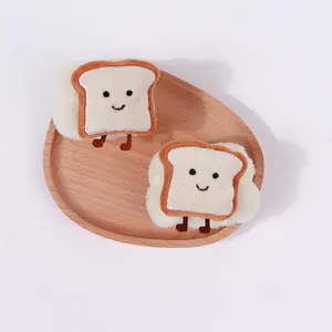 Detailaufnahme süßer Plüsch-Toast-Armbänder zum Gesichtwaschen auf einem Holztablett