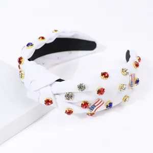 Close-up of white knotted headband with sparkling rhinestones and US flag charm