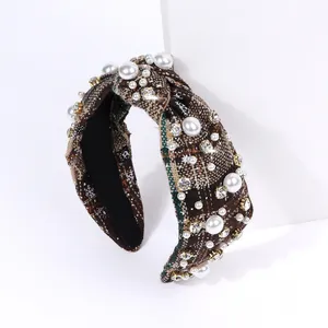 Detail of dark plaid knotted headband featuring white pearls and sparkling rhinestones