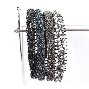 Lot élégant de quatre serre-têtes avec strass et perles sur un support métallique