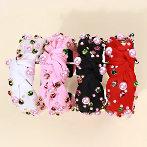 Detail of colorful rhinestones and pearls on knotted wide-brimmed fabric headbands