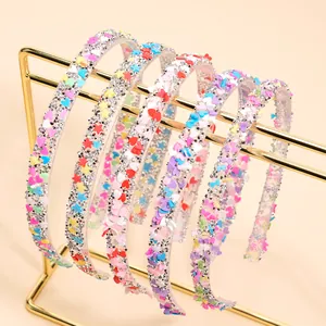 Sparkly kids headbands with colorful glitter hearts and stars on a golden metal display rack
