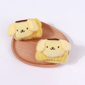 Nahaufnahme gelber Plüsch-Handgelenksbänder mit süßer Pompompurin-Cartoon-Stickerei