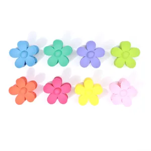 Dettaglio di 8 mollette per capelli a fiore in colori diversi con finitura opaca