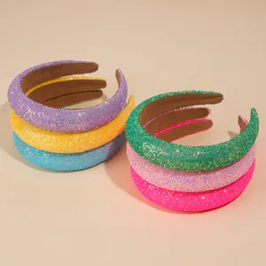 Pile of colorful sequined sponge headbands in purple, yellow, blue, and pink shades