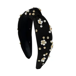 Detail of black knotted headband featuring camellia flowers, pearls and rhinestones
