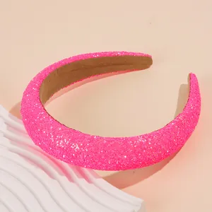 Close-up of glittery neon pink padded headband with soft brown velvet lining texture