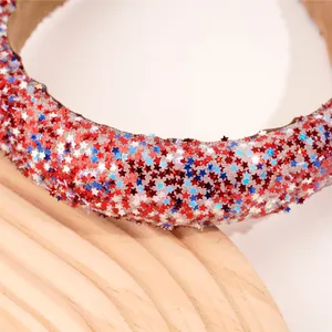 Primer plano de lentejuelas en forma de estrella tricolor sobre una diadema ancha acolchada