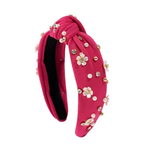 Detail of rose red knotted headband with floral charms, pearls and colorful rhinestones