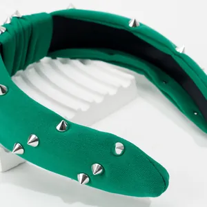 Détail d'un bandeau vert noué avec des clous argentés et une doublure noire antidérapante