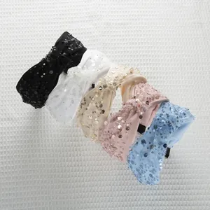 Dettaglio di cerchietti con paillettes annodati in cinque colori con mesh e perline