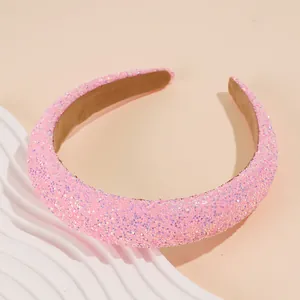 Close-up of pink glitter padded headband with sparkling texture and brown velvet lining