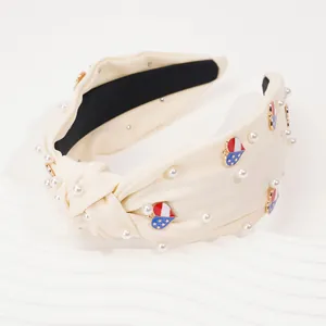 Knot headband with pearls and American flag heart charms on soft cream fabric
