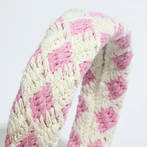Close-up of pink and cream checkered crochet headband showing thick knit texture