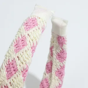 Macro detail of pink and cream crocheted headband showing fine knit texture and ribbon wrap