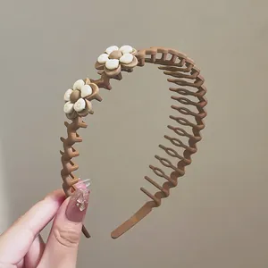 Dettaglio del cerchietto marrone antiscivolo con decorazioni floreali in crema 3D