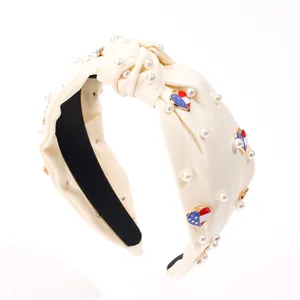 Knot headband with pearls and heart-shaped American flag pendants on white satin