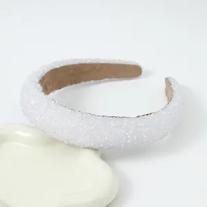 Elegante brede parelhaarklem met witte kralen op een gegolfd keramisch dienblad