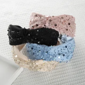 Dettaglio di cerchietti in rete con paillettes e nodo nei colori rosa, nero e blu