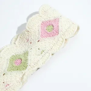Close-up of crochet floral headscarf with pink flower embroidery and wavy edges