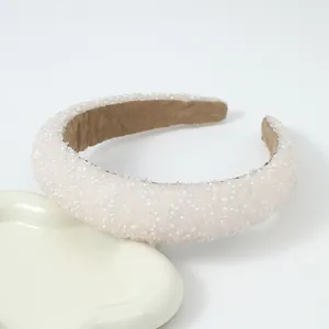 Detailopname van brede roze haarband met parels en fonkelende steentexturen