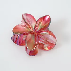 Detailansicht der irisierenden Haarklammer mit rosa Farbverlauf und Frangipani-Blütenform