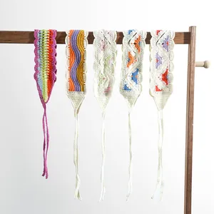Detail view of five assorted crochet flower headbands with bohemian patterns on a wooden rack