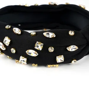 Macro shot of sparkling crystal rhinestones set in gold claws on a black knotted headband