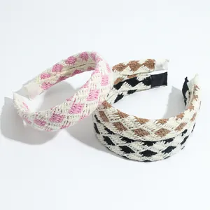 Detail of three woven plaid headbands in pink, brown and black with soft texture