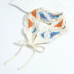 Detailed macro view of a handmade crochet floral headband with orange and blue patterns