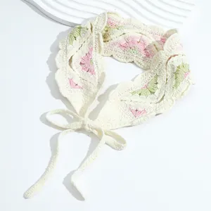 Detailed macro shot of handmade crochet headband featuring pink floral knit patterns