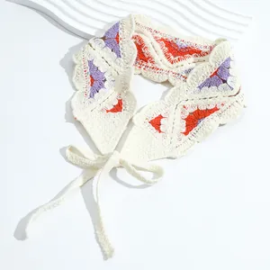 Detail of hand-crocheted floral bandana with orange and purple patterns on white background