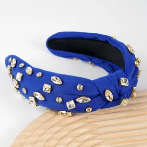 Macro detail of dark blue knotted headband with sparkling rhinestones and metal claw settings