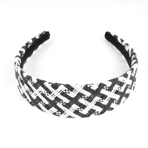 Detail of black and white woven raffia headband showing intricate checkered texture