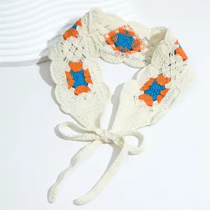 Close-up of handmade crochet floral headband with orange and blue knit patterns
