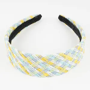 Detail of colorful raffia woven headband featuring multi-colored braided texture and black lining