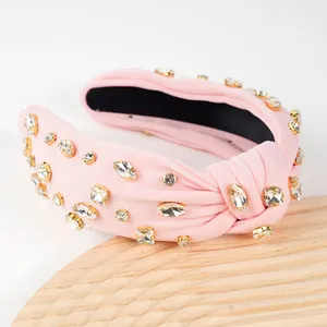 Close-up of light pink fabric knotted headband with glittering crystal rhinestones