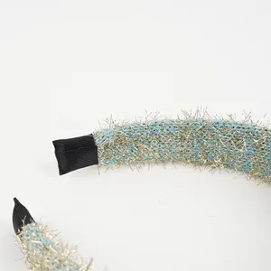 Sparkling light blue knitted headband with golden glitter thread and black wrapped ends