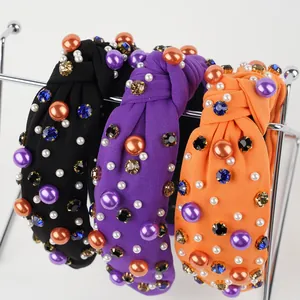 Close-up of knotted velvet headbands with colorful pearls and sparkling rhinestones