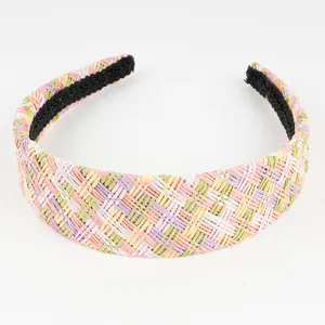 Close-up of a colorful checkered raffia woven headband with a soft black inner lining