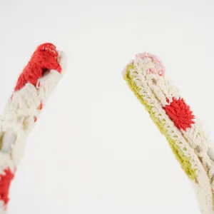 Macro detail of hand-knitted floral headband with colorful cotton yarn textures