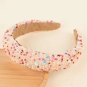 Détail du serre-tête rembourré avec perles colorées et motifs de smileys pastels