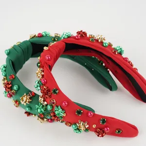 Detail of Christmas headband with pearls, golden stars and red green gemstones
