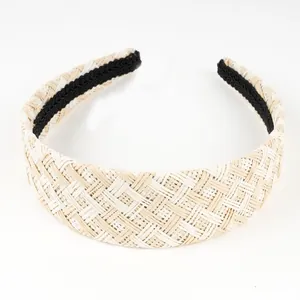 Close-up of hand-woven raffia headband showing beige checkered pattern texture