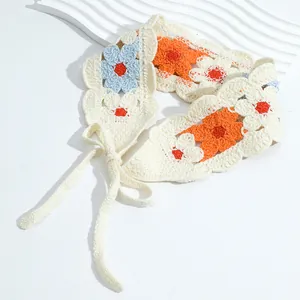 Close-up of handmade crochet floral headband with beige, orange and blue flower patterns