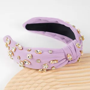 Detail of lavender knotted headband with clear crystals on a light wood background